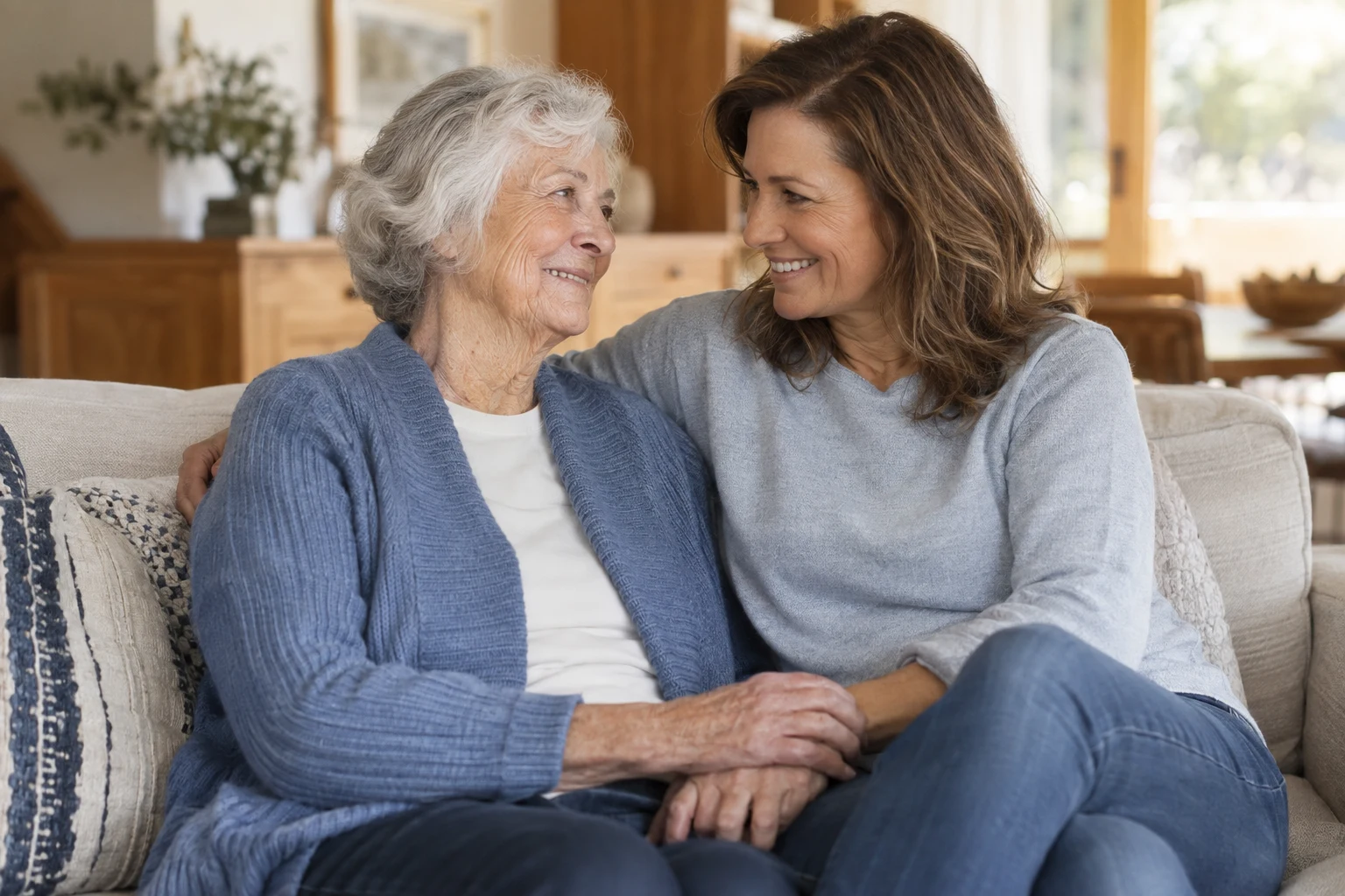 An older woman and her adult daughter sharing a relaxed moment at home